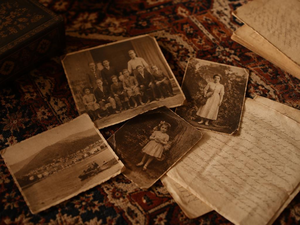 Vieilles photos de famille et lettres posées sur un tapis persan